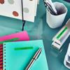 Brother label maker on desk with colorful notebooks and office supplies