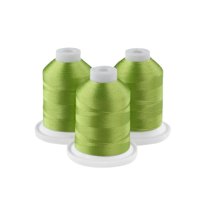 Three grass green embroidery thread spools on white bases