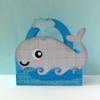Gray whale-shaped fabric bag with blue handle and decorative water spout on ocean waves