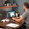 Man working on laptop at home office desk with Brother portable scanner and documents