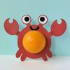 Orange wireless speaker with red paper crab craft decoration on light blue background