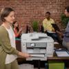 Woman using Brother all-in-one printer in collaborative office workspace