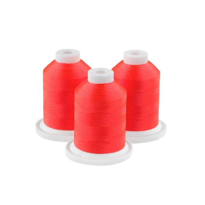 Three spools of bright red embroidery thread on white bases