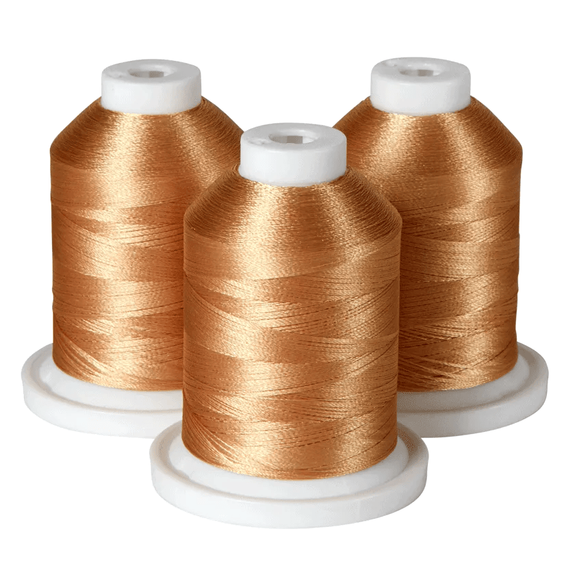 Three spools of gold embroidery thread on white bases
