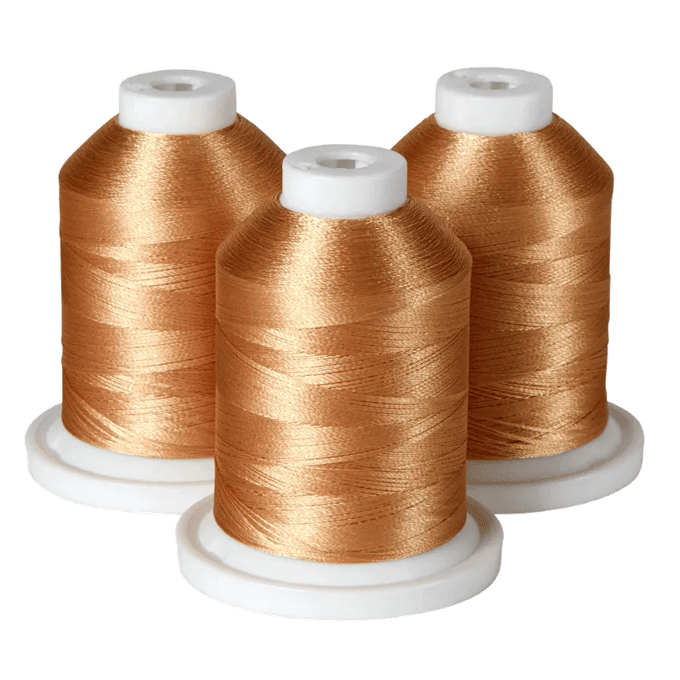 Three spools of gold embroidery thread on white bases