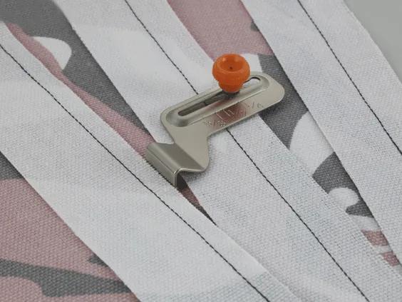 Brother sewing machine presser foot with orange dial on striped fabric