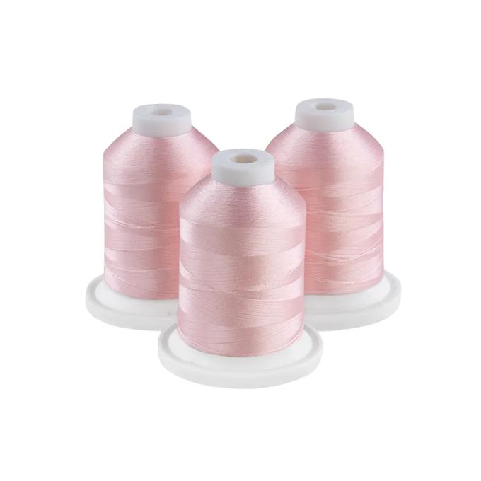 Brother light pink embroidery thread spools on white bases