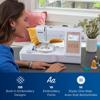 Woman using Brother embroidery and sewing machine with touchscreen at home
