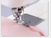Brother sewing machine presser foot stitching pink fabric with white thread