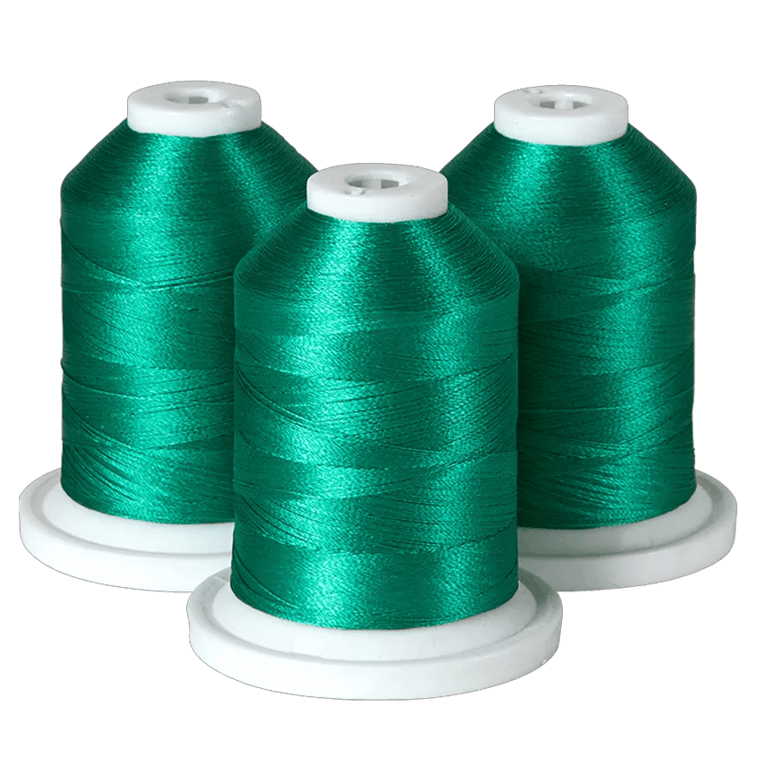 Three spools of emerald green embroidery thread on white bases