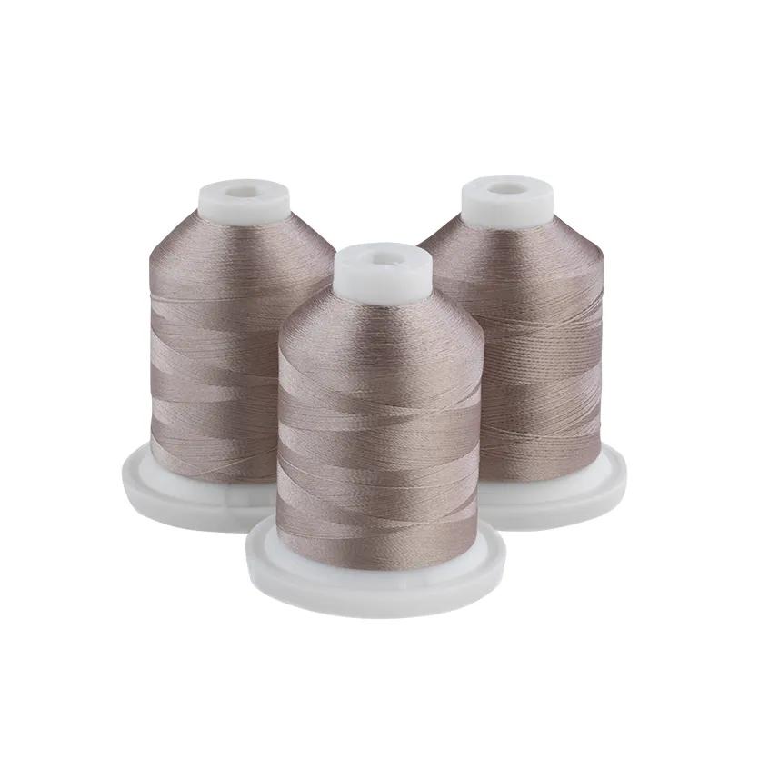 Three spools of Brother embroidery thread in grey-tan on white bases