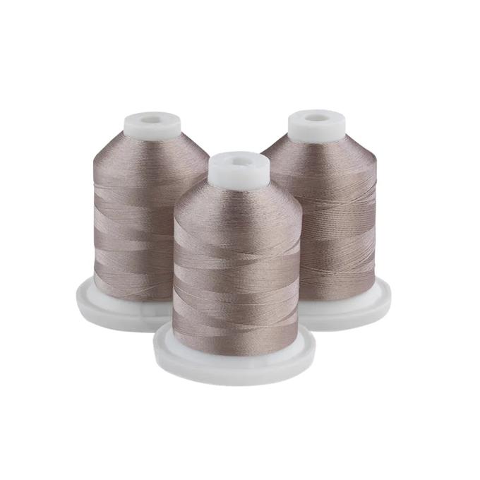 Three spools of Brother embroidery thread in grey-tan on white bases