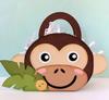 Monkey-shaped party favor box with handle and tropical leaf decoration