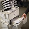 Brother laser printer with high-capacity paper tray being accessed by user in office setting