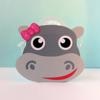Gray hippo-shaped craft project with pink bow and red smile on white surface