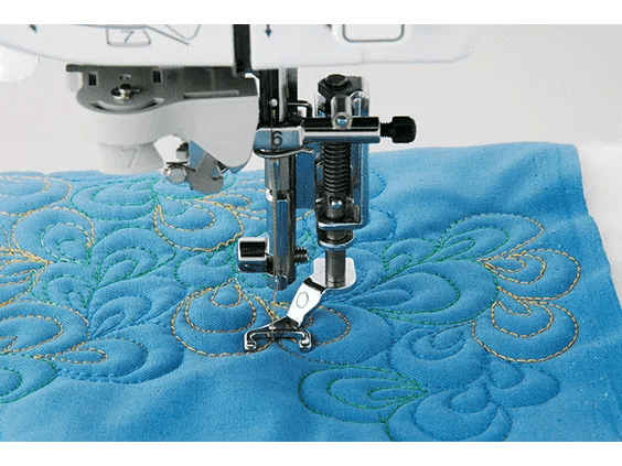 Brother sewing machine quilting foot stitching decorative swirl pattern on blue fabric