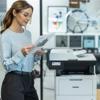 Woman reviewing printed document next to Brother MFC-L5710DN monochrome laser all-in-one printer