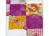 Colorful patchwork quilt with floral embroidery and decorative stitching on fabric squares
