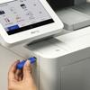 Hand inserting USB drive into Brother MFC all-in-one printer with touchscreen display