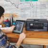 Brother MFC-J1010DWF all-in-one wireless inkjet printer on desk with person using tablet