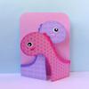 Pink and purple dinosaur-shaped paper craft card with heart pattern design
