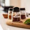 Brother P-touch labeled glass spice jar with chili flakes on wooden board in kitchen