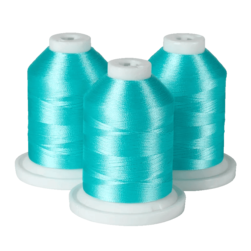 Three turquoise embroidery thread spools on white bases