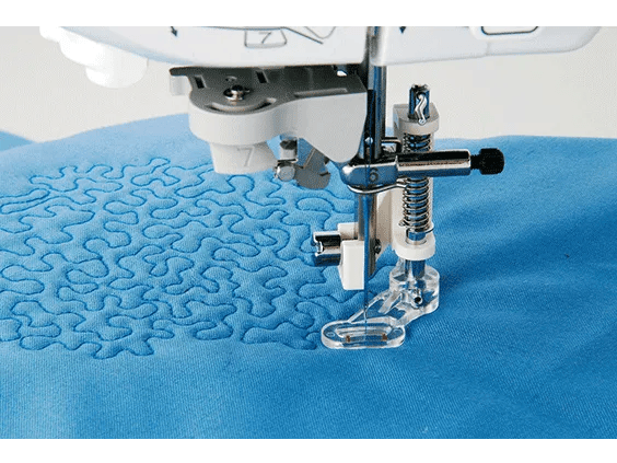 Brother sewing machine quilting foot stitching decorative pattern on blue fabric