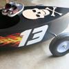 Custom-decorated go-kart with skull design and flame graphics in garage