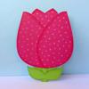 Pink polka dot tulip-shaped fabric craft with green leaves on light blue background
