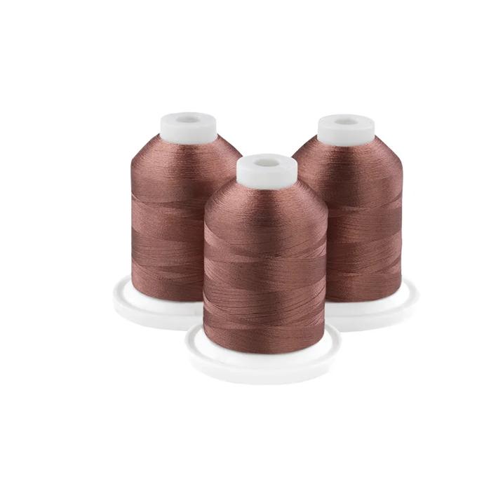 Three cocoa brown embroidery thread spools on white bases