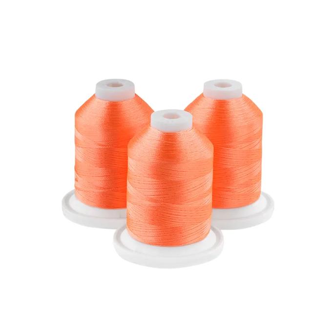 Three orange embroidery thread spools on white bases