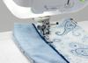 Brother sewing machine presser foot stitching blue paisley fabric with decorative edge