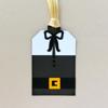 Decorative gift tag with black bow design and gold ribbon attachment