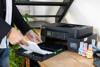 Persona cargando papel en impresora Brother MFC-T930DW multifunción con tanque de tinta