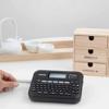 Brother P-touch handheld label maker printing organization labels for wooden drawer storage