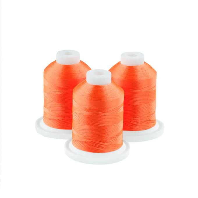 Three neon orange embroidery thread spools on white bases
