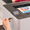 Brother HL-L8430CDW color laser printer with USB drive inserted and colorful document in output tray