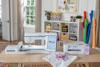Brother Celeste embroidery machine and sublimation printer in bright craft room with colorful fabrics
