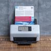 Brother ADS-4700W wireless desktop scanner with touchscreen scanning a document on wooden surface