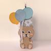 Decorative paper bear craft holding three colorful balloons on neutral background