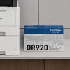 Brother DR920 drum unit beside a wireless laser printer on a desk