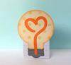 Brother creative center light bulb cutout with orange heart design on blue background