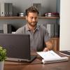 Man reviewing document from Brother portable scanner at home office desk