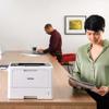 Brother HL-L5210DN monochrome laser printer on office desk with woman reviewing documents