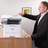 Man using Brother MFC-L5715DW monochrome laser all-in-one printer in modern office