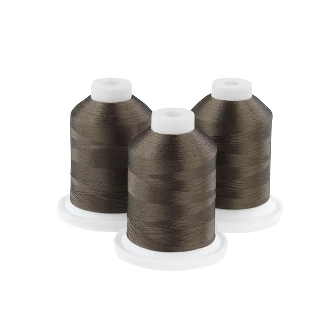 Three spools of dark olive embroidery thread with white caps on white bases