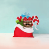 Brother printer cartridges arranged as festive holiday character with candy canes and gift bag