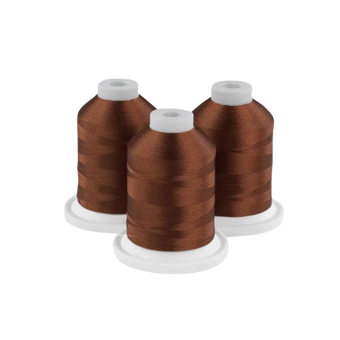 Three spools of milk chocolate brown embroidery thread on white bases