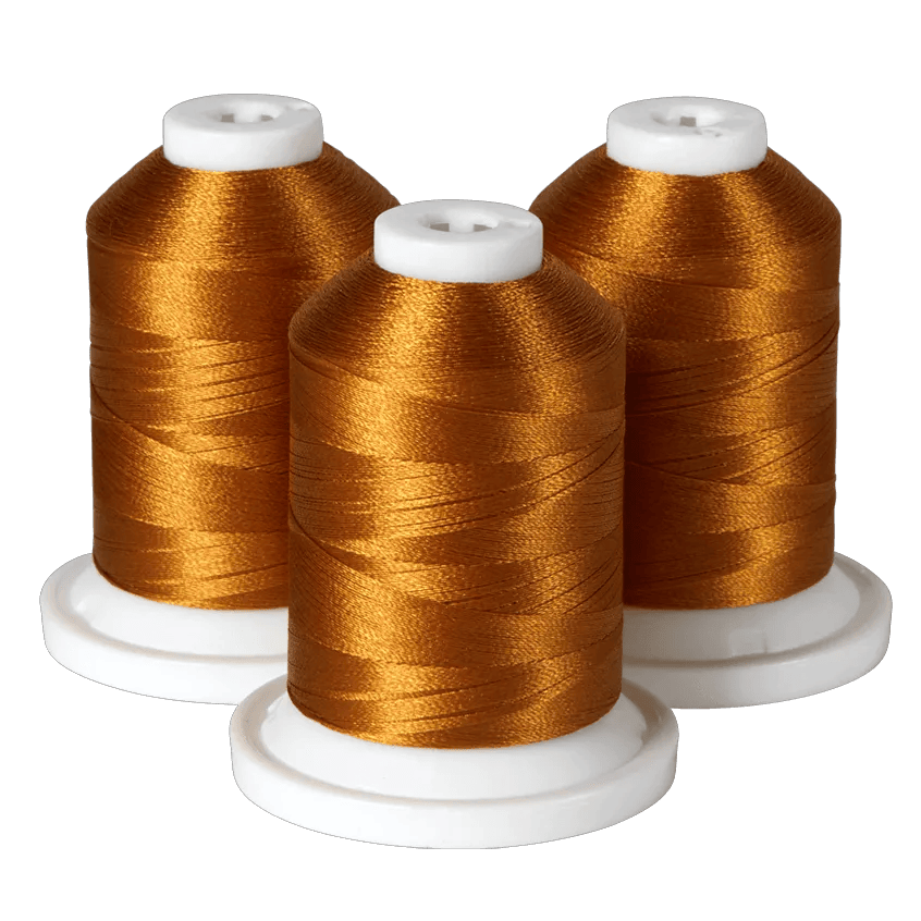 Three spools of golden embroidery thread on white bases for Brother sewing machines